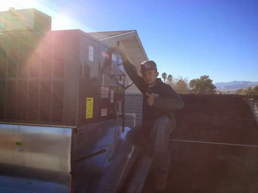 HVAC technician performing Heat Pump Repair on a rooftop unit in Fussels Corner